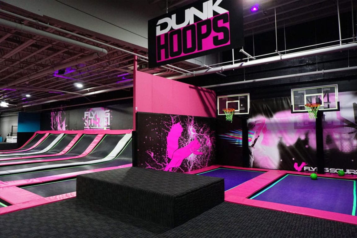 Dunkhoops over trampolines with a sign over head that says "DUNK HOOPS"