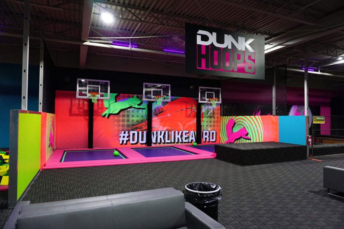 Three dunkhoops with trampolines and a mural that says #DUNKLIKEAPRO