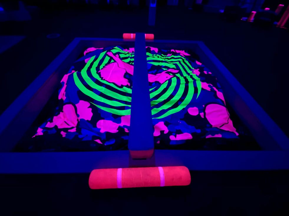 Battlebeam and Joust sticks on top of a UV Reactive foam pit cover.